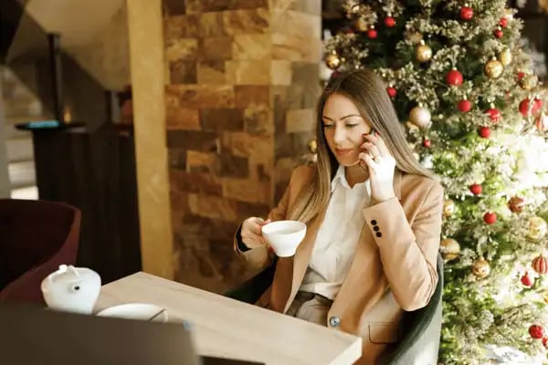 Woman drinking tea while talking over the phone