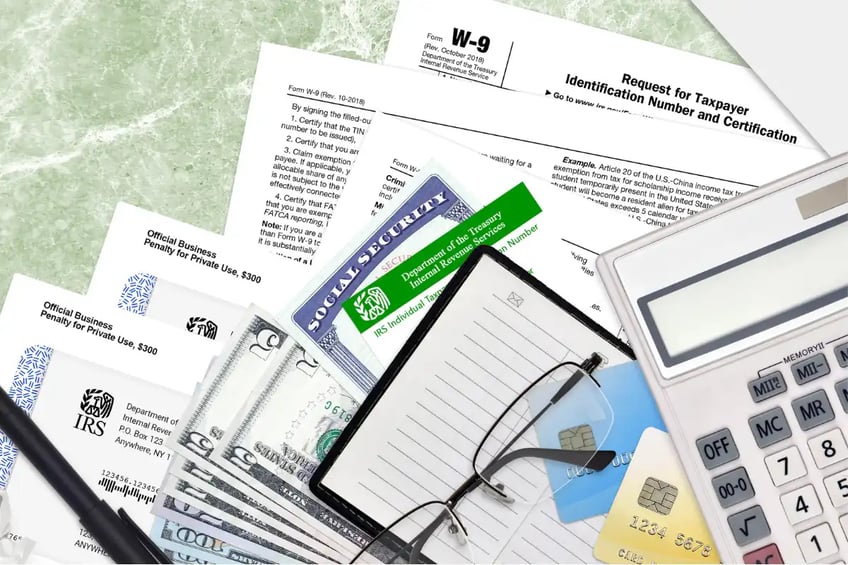 IRS paperwork, glasses, calculator, notes