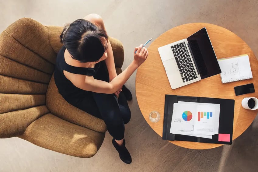 Top-down view of a sitting woman working on charts