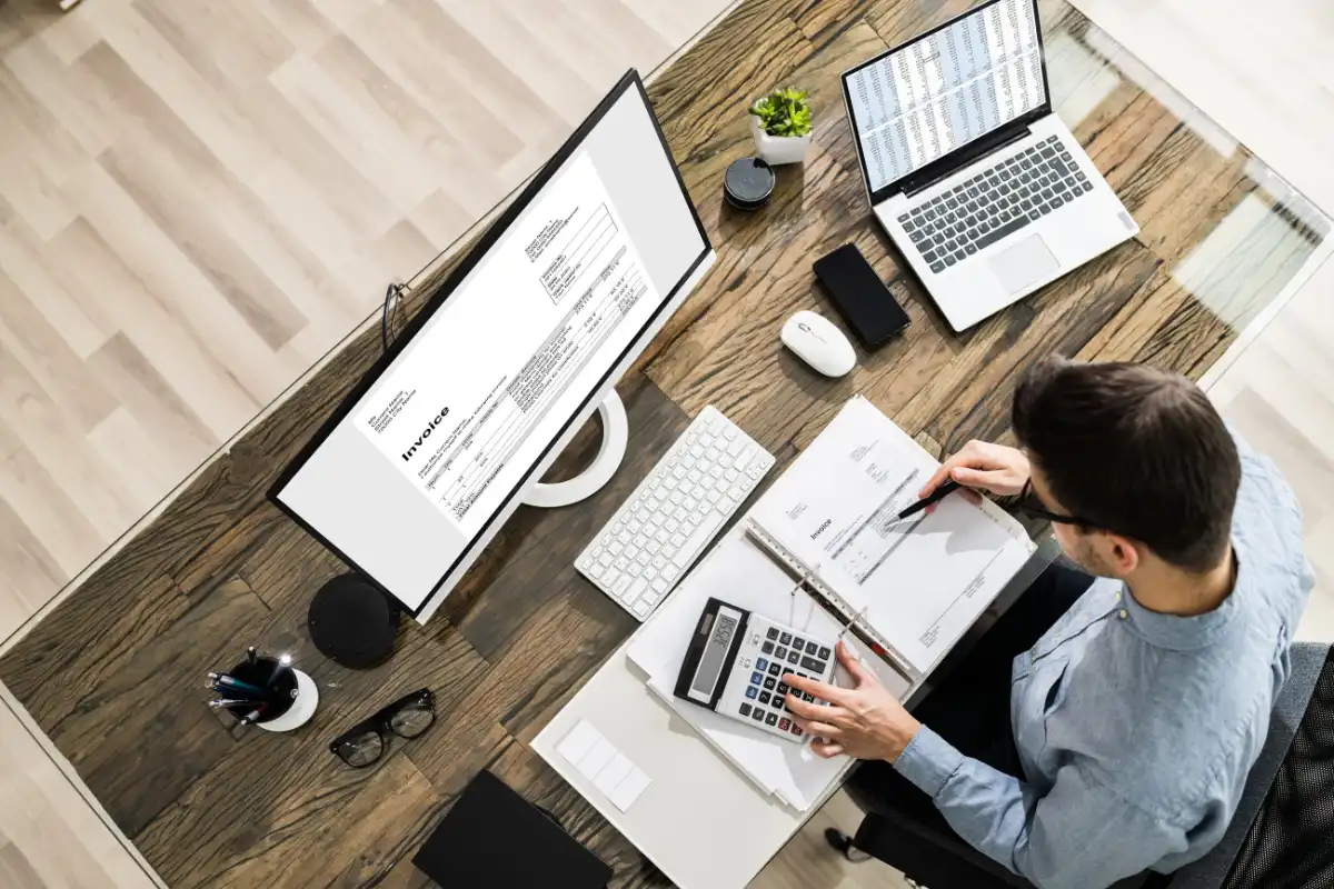 Man at a desk working with calculator and papers